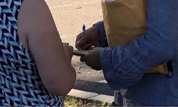 closeup of "protestor" receiving one-half inch stack of currency from "paymaster"